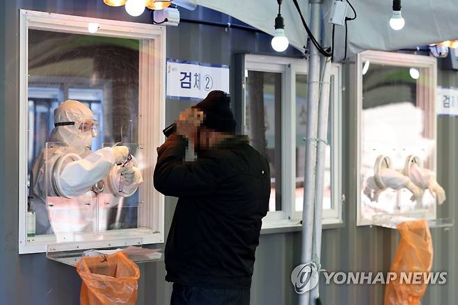 주말에도 코로나19 검사 (서울=연합뉴스) 류영석 기자 = 17일 오전 서울역에 마련된 임시선별검사소에서 의료진과 시민이 검체 채취 전 대화를 하고 있다. 2021.1.17 ondol@yna.co.kr