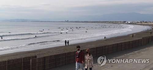 코로나19 신규 확진자가 급증해 긴급사태가 발효 중인 일본 가나가와현의 쇼난 해안에서 17일 오후 쌀쌀한 날씨에도 서퍼들이 겨울 서핑을 즐기고 있다.