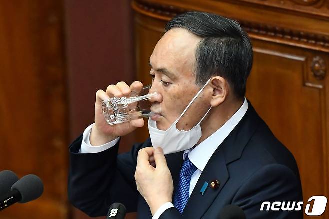 스가 요시히데 일본 총리가 18일 오후 국회에서 통상국회(정기국회) 개회에 따른 시정방침연설을 하기에 앞서 물을 마시고 있다. © AFP=뉴스1