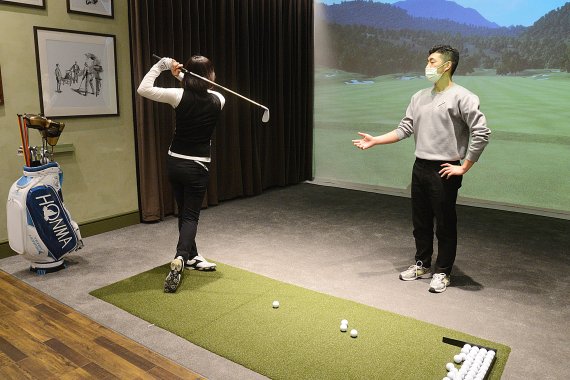 롯데백화점 센텀시티점에 오픈한 골프 스튜디오 '더 프라자'에서 한 이용객이 프로의 레슨을 받고 있다. 롯데쇼핑 제공