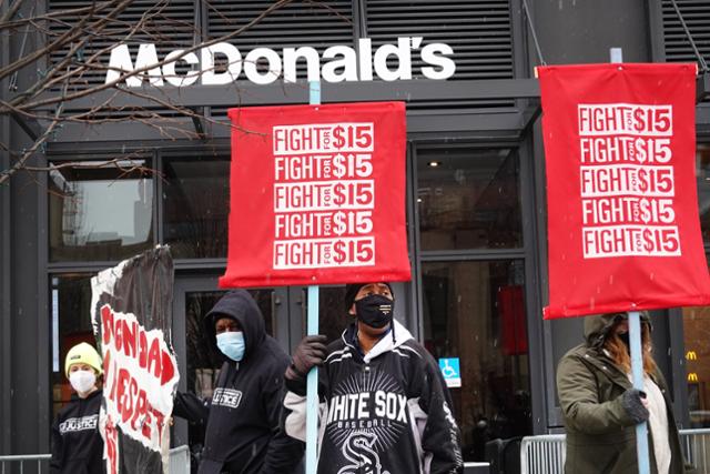 미국 시카코의 맥도널드 본사에서 지난 15일 시간당 최저임금 15달러를 요구하는 시위대들이 피켓을 들고 서 있다. AEP=연합뉴스