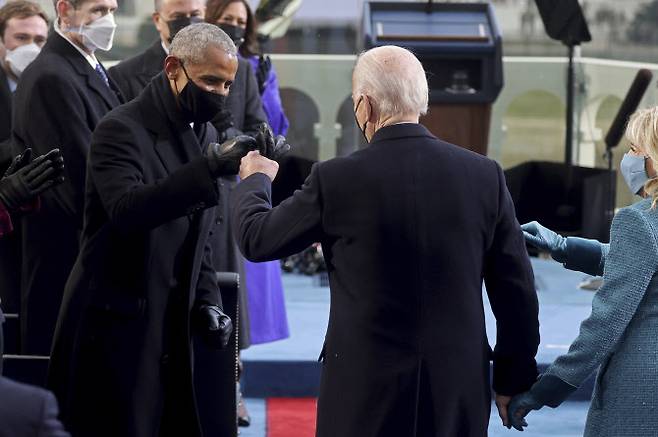 조 바이든 제46대 미국 대통령(오른쪽)이 20일(현지시간) 워싱턴DC 연방 의사당 야외무대에 설치된 취임식장에서 버락 오바마 전 대통령(왼쪽)과 손 인사를 하고 있다. (사진=로이터/뉴시스 제공)