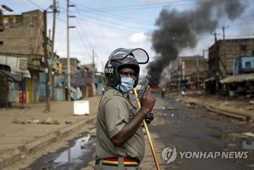 케냐 법원, 야간통금 단속 과정서 폭력 행사한 경찰 15명 기소 2020년 5월 8일(현지시간) 케냐 수도 나이로비의 카리오방기 빈민가에서 시위를 진압하던 한 경찰이 매서운 눈초리로 권총을 들어 보이고 있다[AP=연합뉴스]