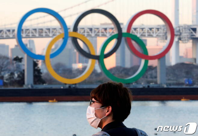 일본 도쿄의 올림픽 상징물 앞으로 한 행인이 마스크를 쓴 채 지나가고 있다. © 로이터=뉴스1