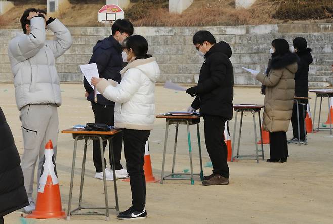 지난해 12월23일 대구 수성구 경북고등학교 운동장에서 수험생들이 수능 성적표를 받고 있다. [연합]