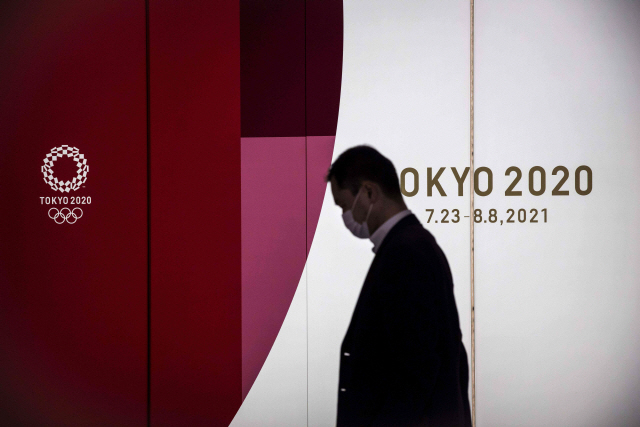 한 시민이 도쿄올림픽 장식판을 지나고 있다./AFP연합뉴스