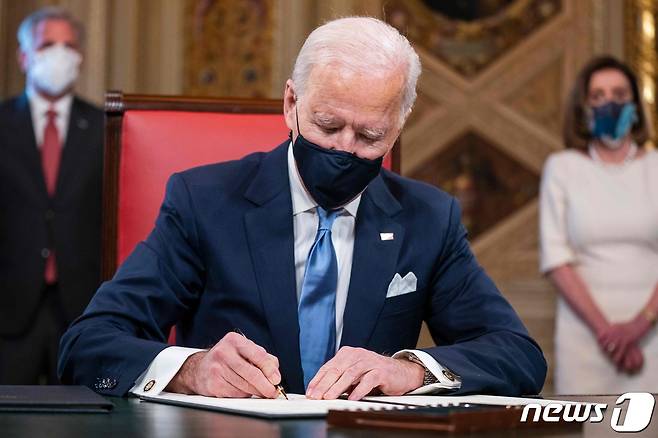 조 바이든 미국 대통령이 워싱턴 백악관에서 취임 후 첫 업무로 파리 기후변화 협약 복귀 등 3건의 행정명령에 서명을 하고 있다. © AFP=뉴스1 © News1 우동명 기자