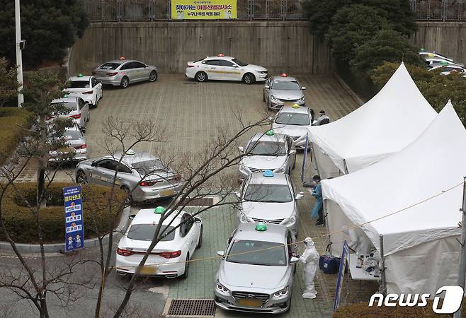 지난 11일 오후 부산 연제구 부산아시아드주경기장 주차장에서 택시 기사들이 드라이브 스루로 신종 코로나바이러스 감염증(코로나19)검사를 받고 있다. 2021.1.11/뉴스1 © News1 여주연 기자