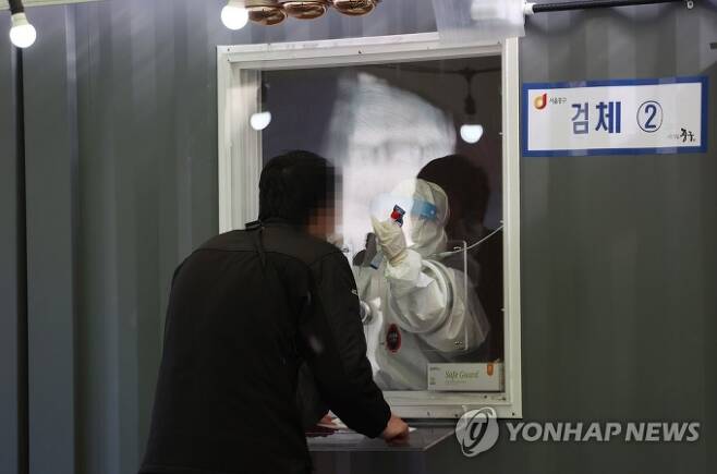 사진=서울역광장에 설치된 임시선별진료소에서 의료진이 검체를 채취하고 있다. 연합뉴스