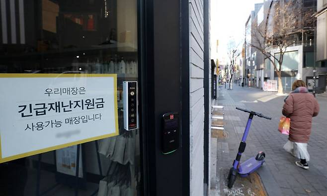 서울 중구 명동거리의 한 상점에 긴급재난지원금 사용 가능 매장임을 알리는 안내문이 붙어 있다. 뉴스1