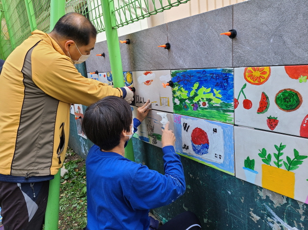 22일 서울 양천구 신월2동 ‘한아름어린이공원’에서 주민과 아이들이 그림타일을 붙이고 있다.양천구 제공