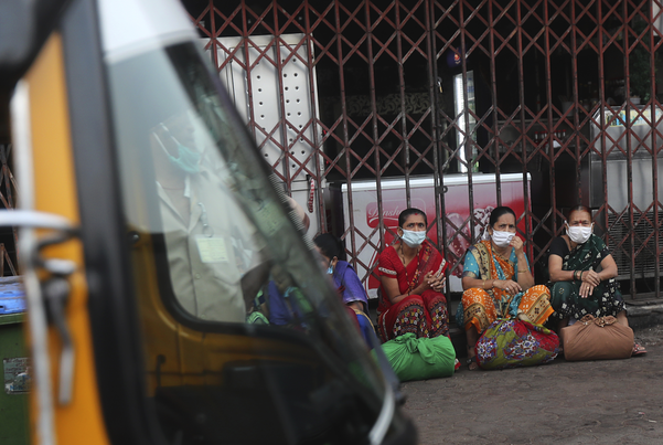 인도 뭄바이의 아시아 최대 슬럼가인 다라비 지역에서 마스크를 착용한 여성들이 버스를 기다리고 있다. /AP연합뉴스