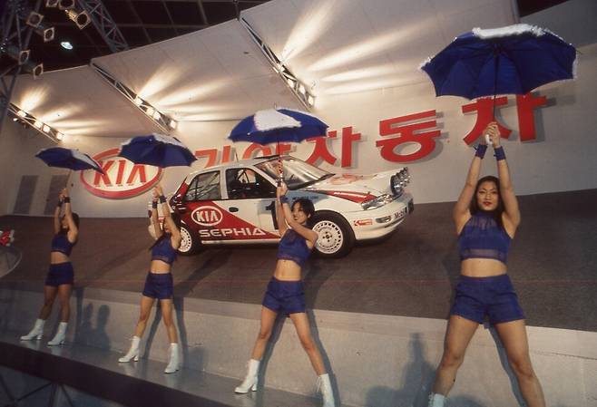 1997년 4월 서울 삼성동 코엑스에서 열린 제2회 서울모터쇼 기아홍보관 앞에서 여성 모델들이 춤을 추고 있다. 당시엔 이런 홍보를 했다. 당시 지면에 소개되지 않았던 비컷이다. 이종찬 기자가 찍었다.