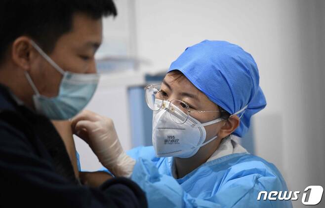 중국의 한 의료인이 지난 15일 백신 주사를 놓아주고 있다. © AFP=뉴스1
