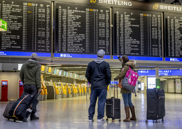 26일(현지 시간) 독일 프랑크푸르트 국제 공항에서 탑승객들이 전광판을 보고 있다. 코로나19 확산 영향으로 공항은 텅 비어 있다./AP연합뉴스