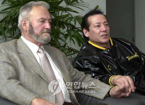 2001년 4월 김동광 당시 삼성 썬더스 감독이 아버지 조지 프레츠 씨의 손을 잡고 기자들의 질문에 답하고 있다. [연합뉴스 자료사진]