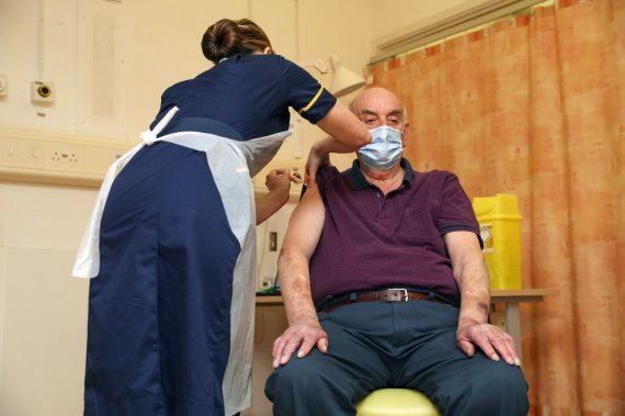 지난 4일(현지시간) 영국 옥스퍼드에서 82세 남성 브라이언 핀커가 영국 최초로 아스트라제네카의 코로나19 백신을 접종받고 있다.AP뉴시스
