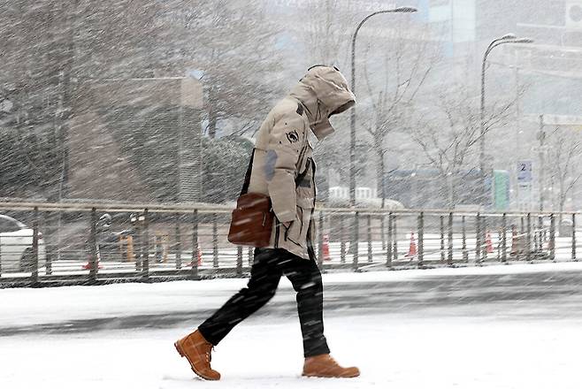 서울·경기북부 지역에 대설주의보가 내려진 28일 오전 서울 청계광장 인근에서 한 시민이 눈을 맞으며 걸어가고 있다. 연합뉴스