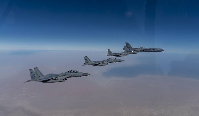 사우디아라비아 공군 F-15s 전투기 편대의 엄호를 받으며 페르시아만 상공을 비행하는 B-52 전략폭격기(오른쪽) 사진을 미 공군이 27일(현지시간) 공개했다. AP연합뉴스