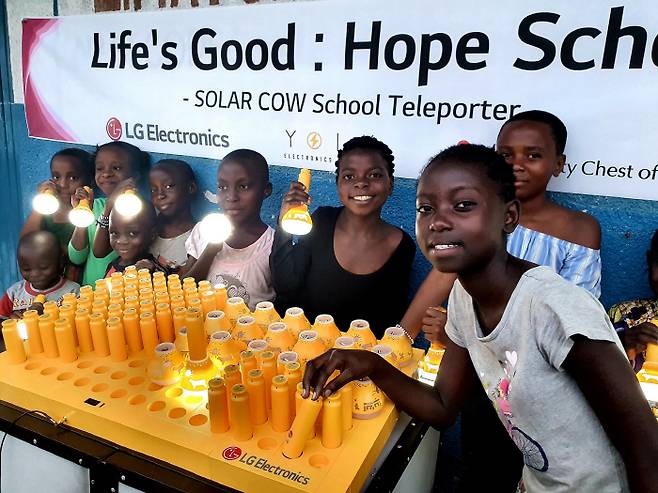 LG전자가 최근 아프리카 콩고민주공화국의 동부지역에 있는 고마시의 초등학교를 대상으로 교육환경을 개선하고 전기 공급을 도와주는 `LG 희망학교` 프로젝트를 시작했다. 프라하(Furaha) 초등학교 학생들이 LG전자가 설치한 친환경 태양광 충전시스템 `솔라카우`를 이용해 충전한 휴대용 보조 배터리를 사용하며 기뻐하고 있다. [사진 제공 = LG전자]