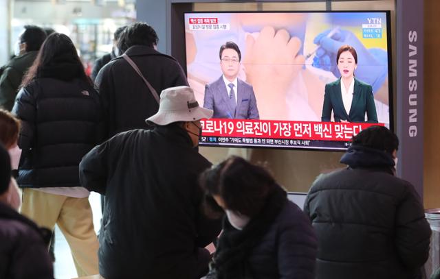 28일 서울역 대합실에서 시민들이 정부가 발표한 코로나19 예방접종 계획 관련 뉴스를 시청하고 있다. 뉴스1
