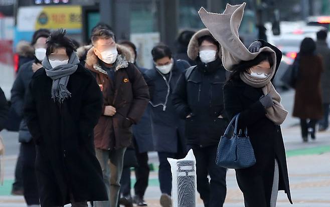 시민들이 29일 오전 강풍이 부는 서울 종로구 광화문네거리를 지나고 있다. 이날 기상청은 강풍을 동반한 이번 추위가 주말 낮부터 영상권을 회복하며 누그러질 것으로 예보했다. 뉴스1