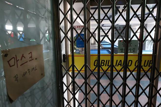 \'마스크 착용\' 문구가 적힌 신촌의 한 당구장 출입구가 철문으로 닫혀 있다. 연합뉴스