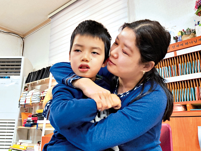 뇌병변장애를 앓는 김키릴군이 지난 19일 광주 갓플리징교회(전득안 목사)에서 엄마 품에 안겨 있다. 밀알복지재단 제공