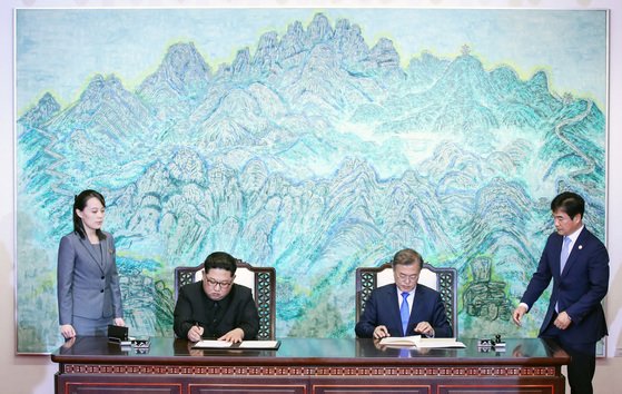 문재인 대통령(오른쪽 두 번째)과 김정은 북한 국무위원장(왼쪽 두 번째)이 2018년 4월 27일 남북 정상회담에서 한반도의 평화와 번영, 통일을 위한 판문점 선언문에 서명하고 있다. 왼쪽은 김 위원장 동생인 김여정 노동당 제1부부장, 오른쪽은 조한기 당시 청와대 의전비서관. [청와대사진기자단]