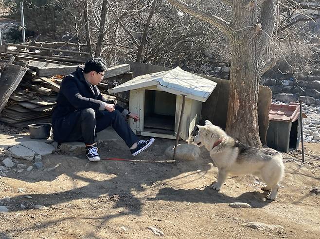 짧은 줄로 발목을 묶고, 멍순이 옆에서 함께하고 있는 기자. 녀석은 늘 내쪽을 바라보았다. 흰 지붕의 집은 멍순이가 여름에 머물고, 빨간 지붕 집은 겨울에 머문단다./사진=최은솔 MBC 작가. 시골개, 1m의 삶 체헐리즘은 3월9일 밤 9시20분 MBC '아무튼 출근!'에서 방송된다.