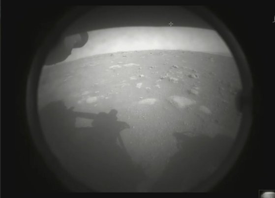 퍼서비어런스가 2월 18일(현지시간) 화성 착륙에 성공하고 몇분 뒤 지구로 전송한 첫번째 사진. 퍼서비어런스의 그림자와 화성의 표면이 선명하다. [사진=나사(NASA) 제트추진연구소]