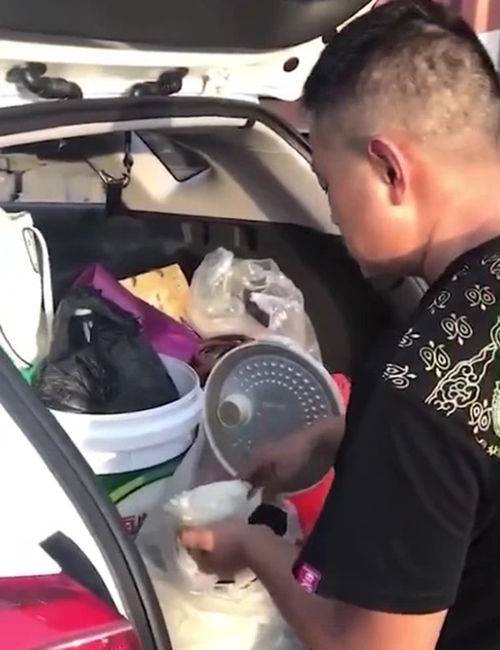 귀경길 고속도로가 정체를 빚자 차량 트렁크에 있는 전기밥솥에서 밥을 푸고 있는 장면 (사진=바이두 캡처)