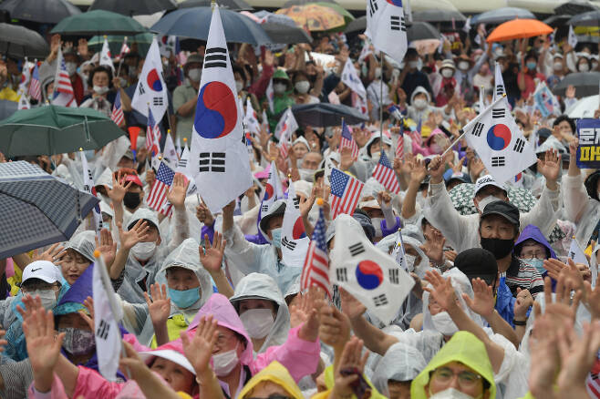 지난해  8월 15일 오후 서울 종로구 동화면세점 앞에서 열린 보수단체의 광복절 집회에서 참석자들이 태극기와 성조기를 흔들고 있다. 이한형 기자