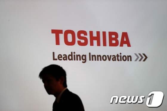 일본 도시바 본사 로비에 새겨진 회사 로고 앞으로 한 남성이 지나가고 있다. 자료사진. AFP뉴스1