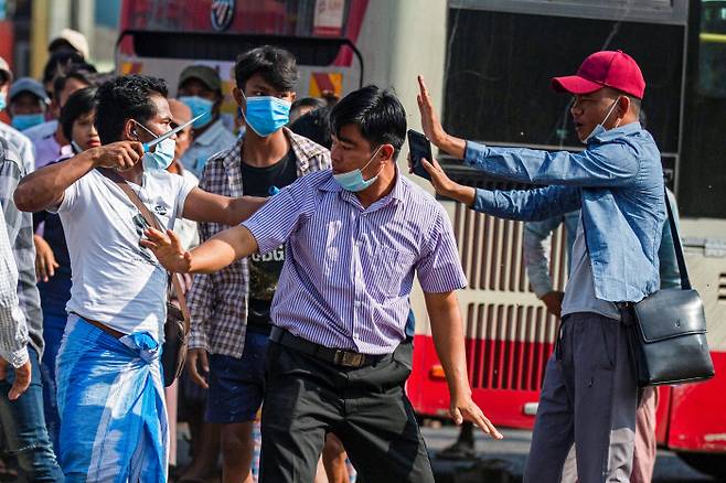 흉기 든 군부 지지자, 쿠데타 반대 시민과 충돌 미얀마 양곤에서 25일 열린 군부 지지 집회 도중 군부 지지자(왼쪽)가 군부 쿠데타에 반대하는 시민에게 흉기를 겨누고 있다. 양곤 | 로이터연합뉴스