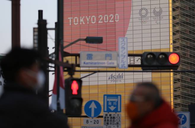 도쿄올림픽 '빨간불' (도쿄=연합뉴스) 이세원 특파원 = 20일 일본 도쿄도 스미다(墨田)구의 한 건물에 도쿄올림픽 홍보물이 설치된 가운데 근처에 보이는 신호등에 적신호가 켜져 있다.