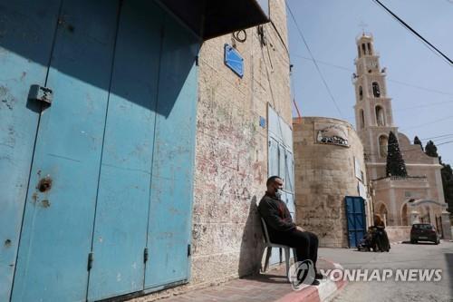 강력한 봉쇄조치 속에 집앞에 나와 앉은 팔레스타인 서안 주민 [AFP=연합뉴스 자료사진]