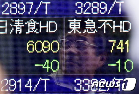 도쿄에서 증시 수치를 보여주는 스크린에 한 남성의 근심어린 얼굴이 비쳐졌다. © AFP=뉴스1