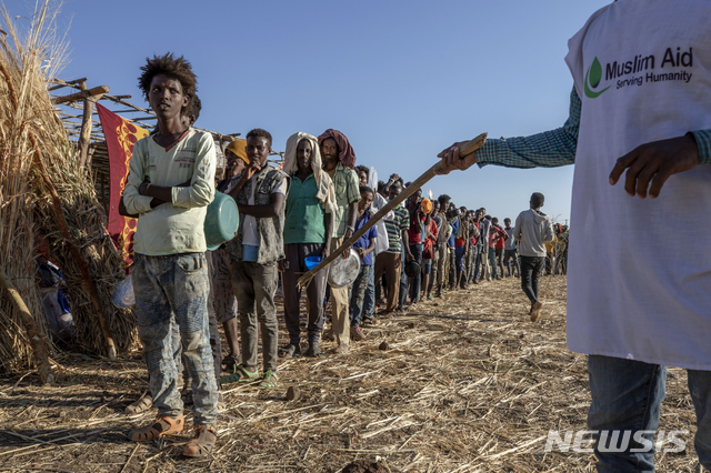 [카다리프(수단)=AP/뉴시스] 12월12일 수단 카다리프의 움 라쿠바 난민수용소에서 에티오피아 티그라이 난민들이 음식을 배급받기 위해 길게 줄지어 서서 기다리고 있다. 에티오피아 서부 지역에서 최근 100명 이상이 숨지는 종족 학살이 벌어졌다고 에티오피아 인권위원회가 23일(현지시간) 발표했다. 위원회는 사망자 수가 앞으로 더 늘어날 것으로 우려된다고 덧붙였다. 2020.12.24