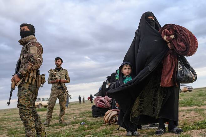 2019년 2월 27일 이슬람국가(IS)측이 장악한 지역을 떠난 시리아 난민이 쿠르드 민병대의 보호를 받고 있다. AFP=연합뉴스