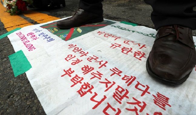 지난 2일 서울 용산구 주한미얀마대사관 앞에서 열린 미얀마 군부 쿠데타 규탄 기자회견에서 한 재한미얀마인이 쿠데타를 일으킨 민 아웅 흘라잉 최고사령관의 사진을 밟고 서 있다. ⓒ 뉴시스