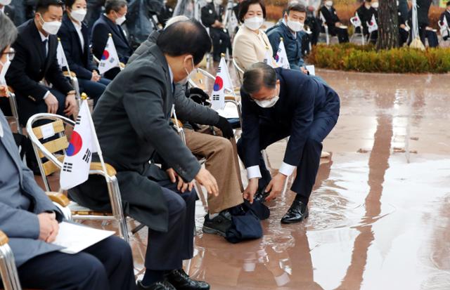 문재인 대통령이 1일 서울 종로구 탑골공원에서 열린 제102주년 3·1절 기념식에 참석해 독립운동가인 임우철 애국지사가 바닥에 떨어뜨린 담요를 주워 주고 있다. 뉴시스
