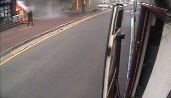 제주여객 소속 버스기사인 김상남씨가 도로변 상가 건물에서 난 불을 진압하고 있다./제주여객 제공 동영상 캡처