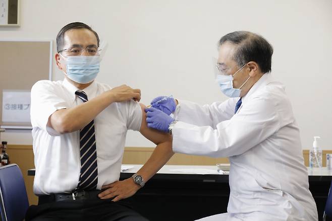 일본에서 코로나19 백신 선행 접종이 시작된 17일 도쿄 메구로(目黑)구에 소재한 국립병원기구 도쿄의료센터의 아라키 가즈히로 원장(왼쪽)이 일본 내 첫 번째 백신 접종 대상으로 선정돼 주사를 맞고 있다. 연합뉴스