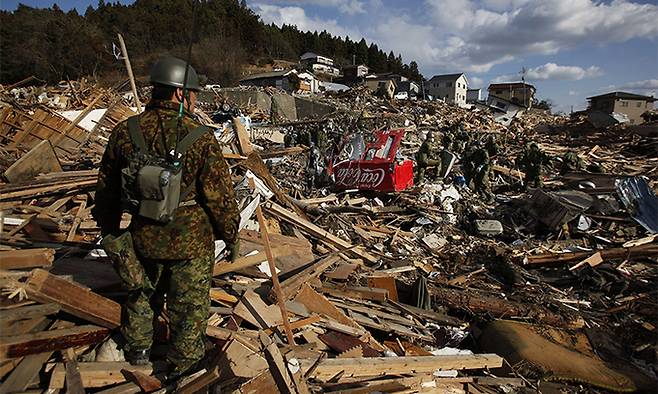 지난 2011년 3월 23일 일본 미야기 현 미나미산리쿠에서 일본 자위대원들이 지진 및 쓰나미 피해 지역에서 복구 작전을 수행하고 있다. AP연합뉴스