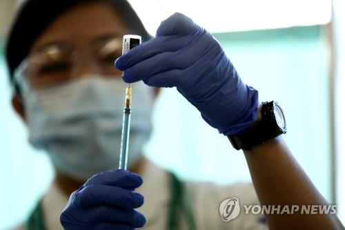 (도쿄 로이터=연합뉴스)지난달 17일 일본 도쿄의 한 의료기관에서 의료 종사자가 화이자의 코로나19 백신을 주사기에 채우고 있다.