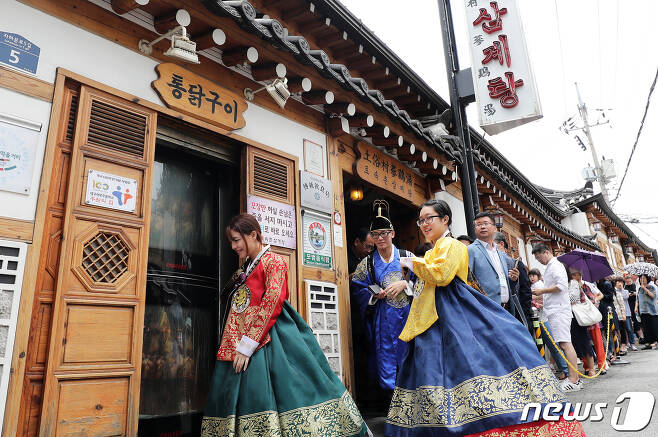 지난해 7월11일 한복을 곱게 차려 입은 외국인 관광객들이 서울 종로구의 한 삼계탕집에서 보양식을 먹은 뒤 자리를 뜨고 있다. 2019.7.11/뉴스1 © News1 오대일 기자