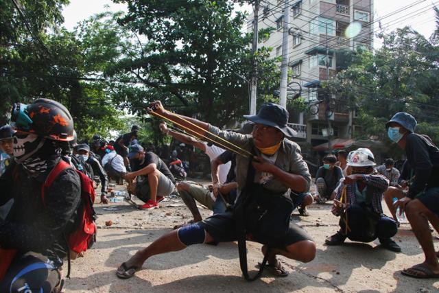 지난달 28일 미얀마 양곤 시위 현장에서 시위대가 새총을 쏘고 있다. 양곤=AP 연합뉴스