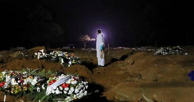 늦은 시간까지 시신을 매장할 땅을 파는 작업에 동원된 묘지 직원의 모습. 로이터 연합뉴스