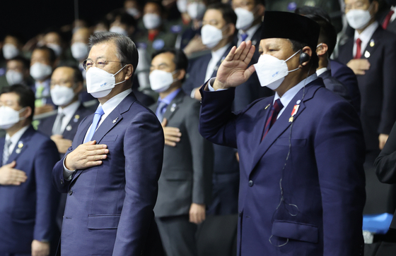 President Moon Jae-in, left, and Indonesian Defense Minister Prabowo Subianto salute the South Korean at Friday's official rollout of the KF-21 Boramae. [YONHAP]